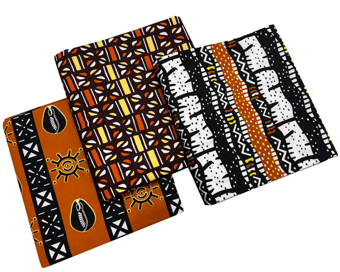 Three folded pieces of African wax print fabric with traditional patterns in orange, black, white, and yellow, displayed on a clean white background.