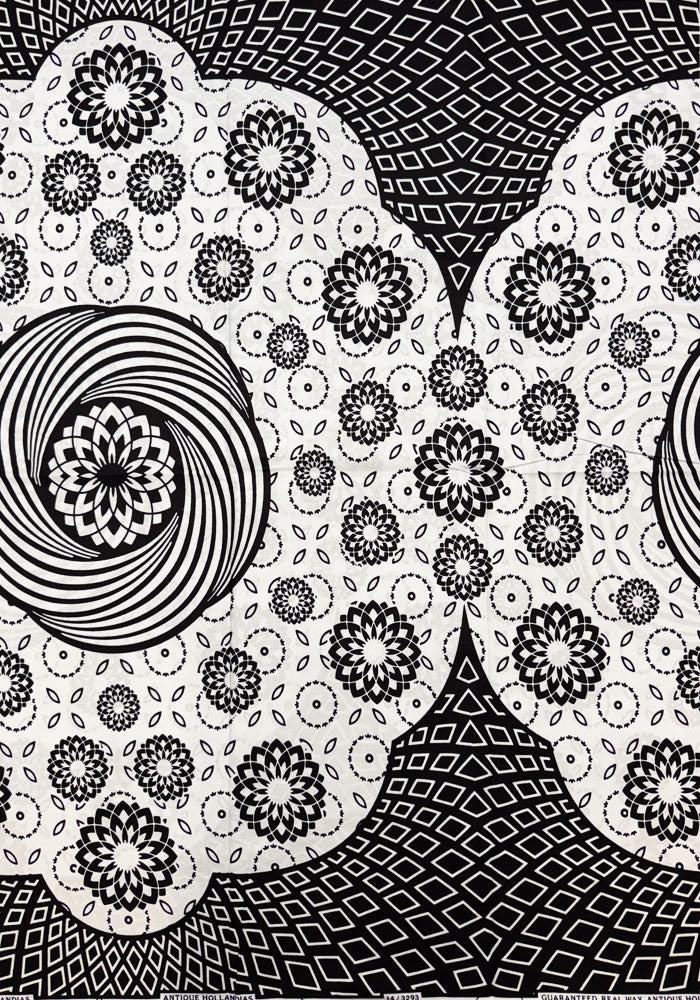 Black and white abstract patterned fabric or wallpaper featuring scalloped shapes with floral mandala motifs, concentric circles, and geometric diamond backgrounds.