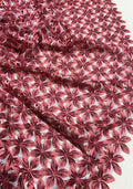 red and pink floral lace fabric with a repeating embroidered starburst pattern